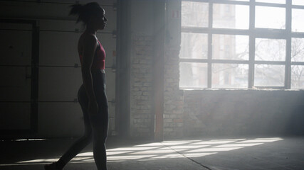 Fototapeta na wymiar Muscular athlete walking in modern gym. Woman going in sport club for training