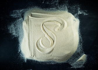 Greek letter delta written on the white sand with black background