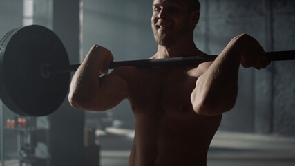 Man lifting weights in gym. Strong guy shoulder press exercise during training