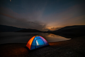 Tent in the  lakeshore in the beautiful mountains. Night camping.