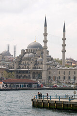 Fototapeta premium Embarcadero en el Bósforo y vista de la mezquita de Yemi Cami en la ciudad de Estambul en Turquía