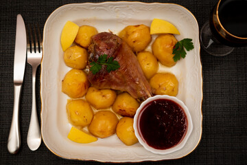 Turkey leg baked with potatoes with cranberry sauce. Delicious food.