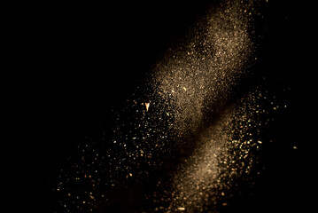 Dust and wood chips on a black background. Dirt particles fly in the air. Layout for design. Some dust particles are blurred to transmit the effect of motion.