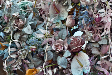 Multicolored flowers and greens on the wall close up. Artificial flowers decorate the interior.