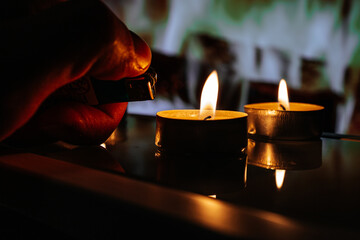 male hand lighting a candle with a lighter. blackout in Europe or Ukraine 