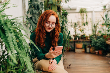 Positive red haired female using a smartphone