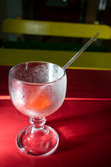 Empty glass on colorful wooden table covered with cold frost.