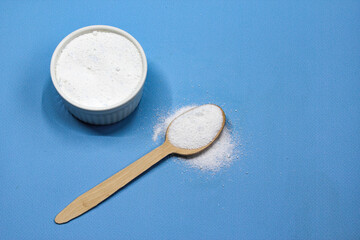 Collagen powder on blue background. Natural health supplement for skin