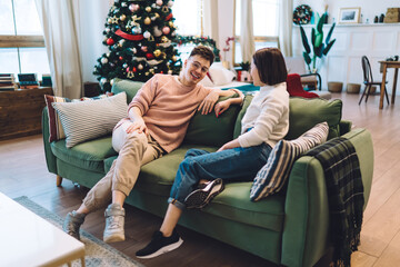 Obraz premium Multiracial couple talk and rest on sofa at home