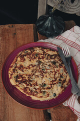 Courgette and onion omelette on a rustic table.