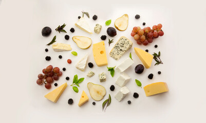 Assortment of different cheese types on white background and grapes as appetizer