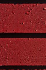 Wooden outdoor wall panel. Red painted house wall. Closeup.