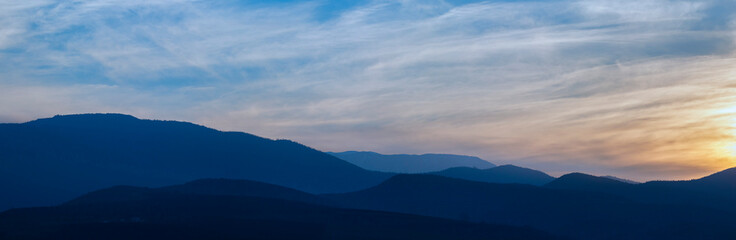 Fototapeta na wymiar Mountains in a misty haze at sunset