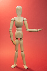 Wooden mannequin holding something, picture with free space to add your material, picture on red background