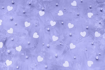 Color of the year 2022 Very Peri. Romantic background with paper hearts and white pearls. Trendy color, love, dating and Valentines Day concept, copy space