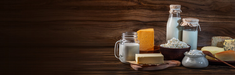 Fototapeta na wymiar Dairy products. Bottles with milk, cheese, sour cream, butter on a wooden background