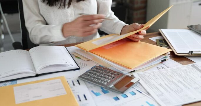 Woman secretary sorting post letters at table in office closeup 4k movie