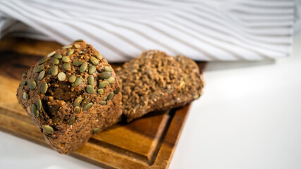 Fresh pastries for breakfast. Bakery bread with seeds on the table.
