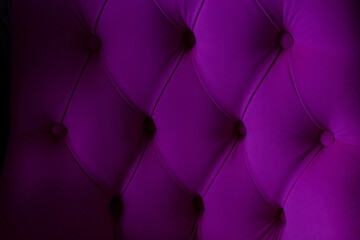 Lilac velour background with quilted upholstery in the style of Chesterfield close-up