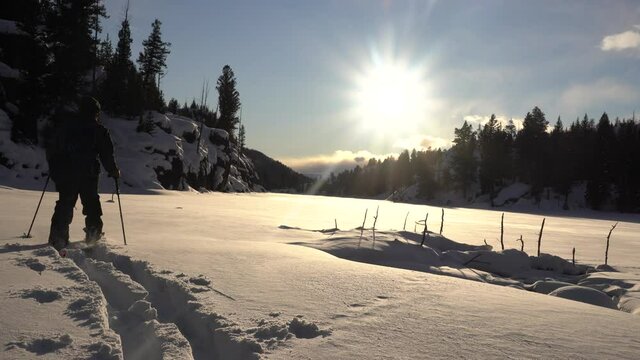 cross-country skier in deep snow at sunset 
