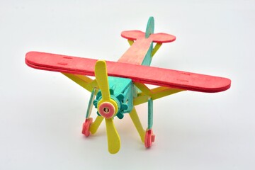 Avión de juguete hecho de madera, pintado de color amarillo, turquesa y rojo