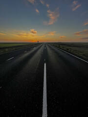 Fototapeta na wymiar Beautiful look of an infinite road, highway going to a sunset in the Iceland highlands