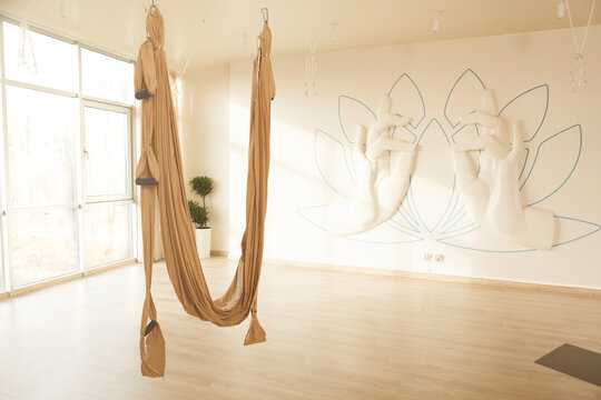 Aerial yoga hammock hanging at empty yoga studio, copy space - Powered by Adobe