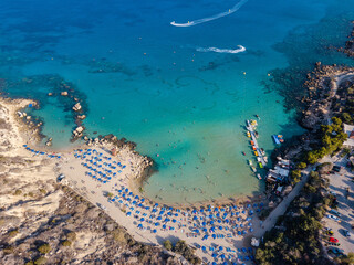 Aerial view on beautiful beach with sun loungers near azure sea