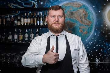 Adult bearded man of European appearance professional bartender shows hand gesture class cool