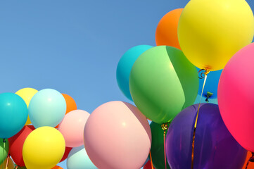 bunch of multicolored balloons in the city festival on clear blue sky background

