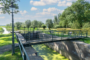 Eemnesser lock in the rural area with a view of the church tower of Eemnes.
