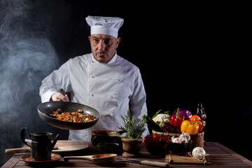 Male cook in white uniform and hat while working in a restaurant kitchen