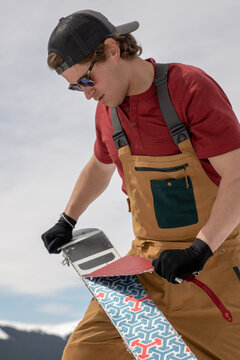 Man removes skins from splitboard in the Colorado Backcountry