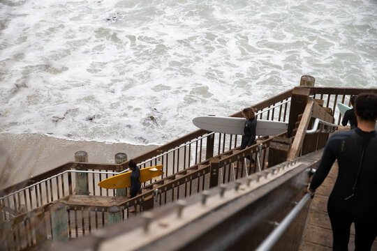 Black Woman carrying a surfboard