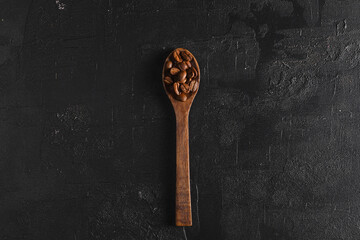 Coffee beans. On a spoon lie on a wooden background.