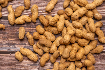 Top view image of peanuts in bulk on wooden table