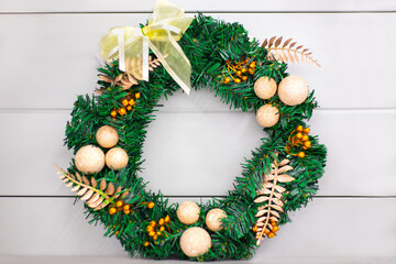 Christmas tree wreath decorated with balls, twigs and a bow. Festive New Year's decor