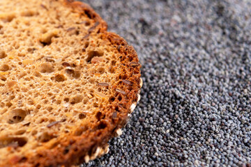 Rustic grain crust without yeast bread. In a pile of poppy seeds. Macro