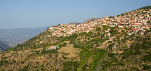Fototapeta na wymiar Panoram of the small town with Red Brick Roof houses on the hill with mountains on the background