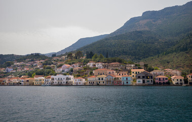 Fototapeta premium Panoram of the small town with multicolored houses on the hill with mountains on the background