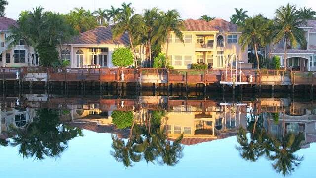 Miami, Florida Intracoastal waterway water Stranahan river and waterfront mansions villas houses real estate at sunset colorful yellow sunlight reflection by dock