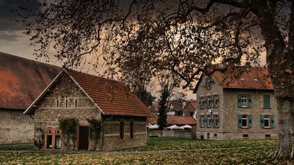 Fototapeta na wymiar Nachklösterliche Gebäude (Zehntscheune, kurfürstliches Haus) des karolingischen Klosters Lorsch bei düsterem Sonnenuntergang