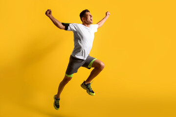 Sporty male runner on color background