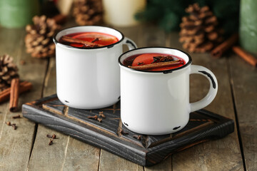 Cups of tasty fruit tea with cinnamon on wooden background