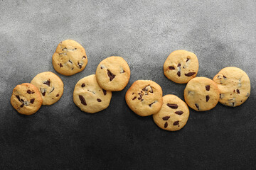 Tasty homemade cookies with chocolate chips on dark background