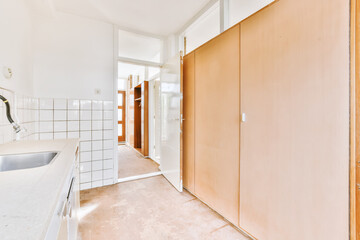 A small room with a wardrobe and an open door leading to another room