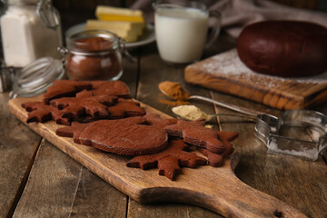 Board with tasty chocolate Christmas cookies on wooden background