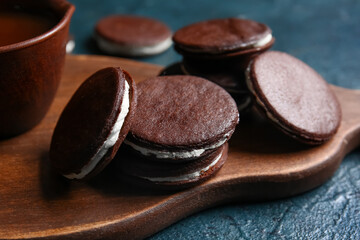 Obraz na płótnie Canvas Board with tasty chocolate cookies on dark background, closeup