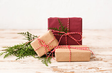 Christmas gift boxes and fir branches on light wooden table