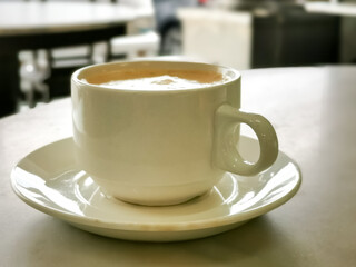 Tea with milk in a cup locally popularly known as Teh Tarik on the table.